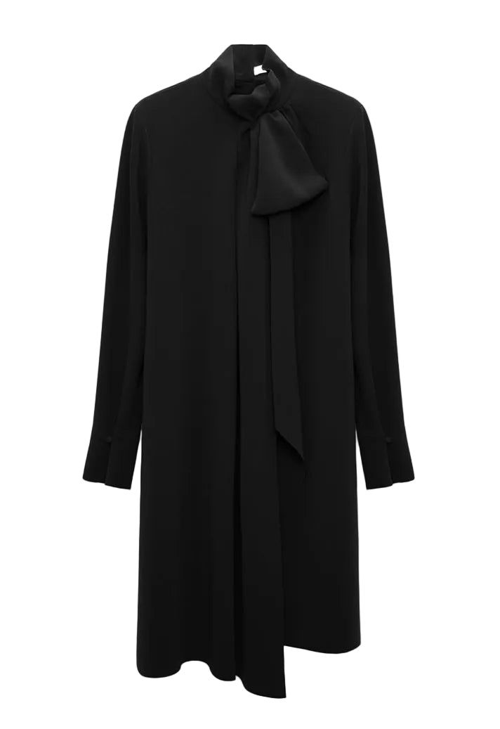 The Statement Drape Dress by Dorothee Schumacher is a long-sleeve black dress made from luxurious Japanese crepe, showcasing a high neckline with a dramatic bow detail at the neck, set against a plain white background.