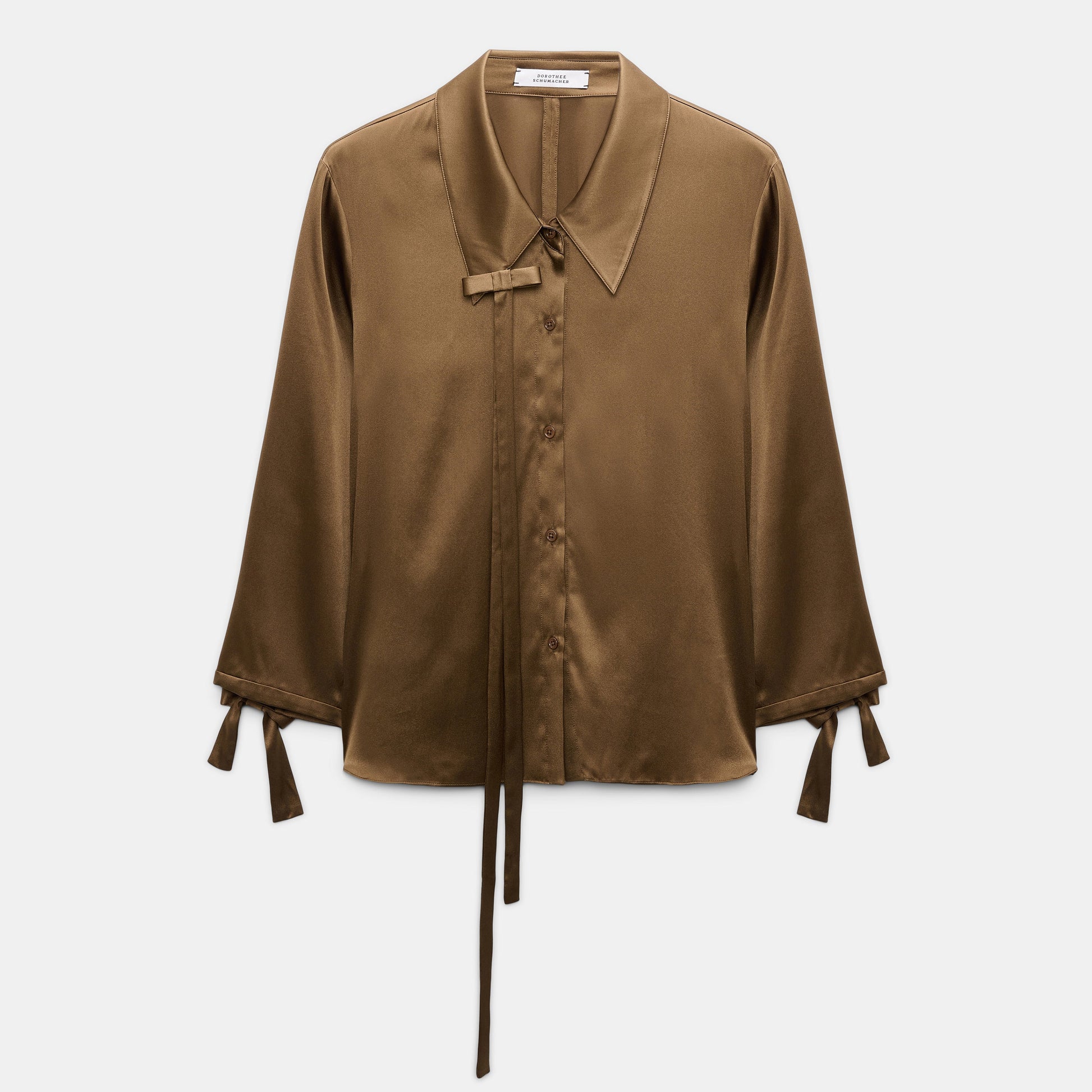 The Sense of Shine Blouse by Dorothee Schumacher is a brown stretch satin slim blouse featuring a pointed collar and removable bow tie details on the collar and cuffs, displayed flat on a white background.