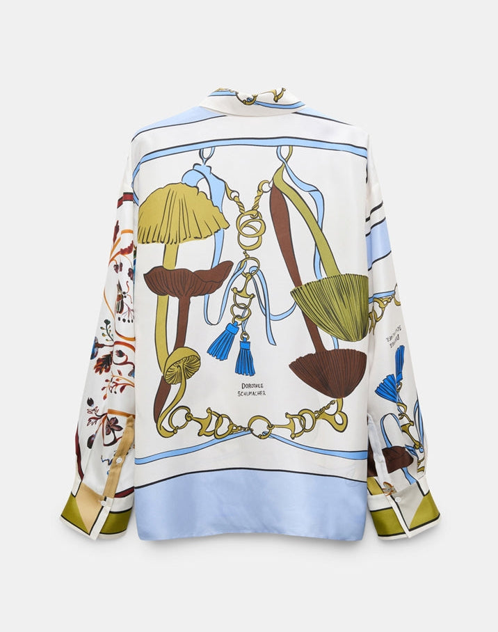 The Cosmic Funghi Blouse by Dorothee Schumacher is an effortless oversized silk twill blouse showcasing a vibrant nature-inspired print of mushrooms, leaves, and decorative ropes on a white background. This striking piece is distinguished by its signature mushroom motif for added charm.