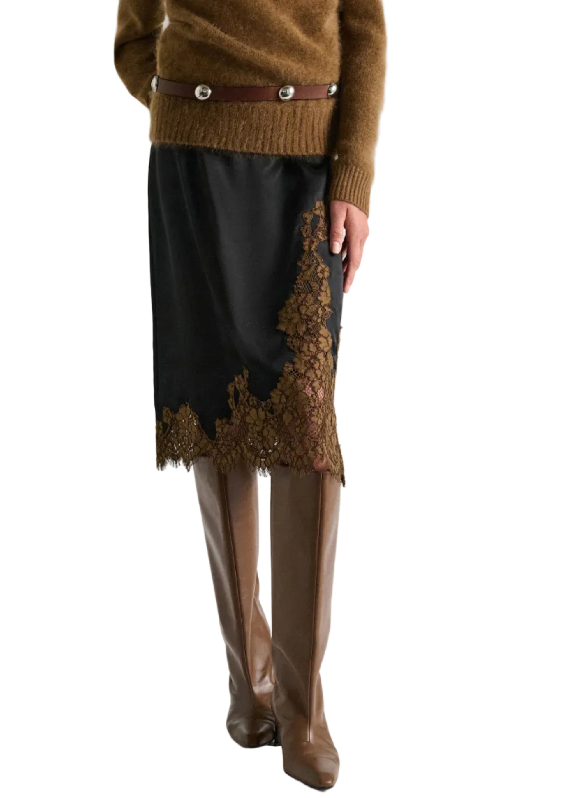A person wearing a brown sweater, a brown belt with silver buttons, Dorothee Schumacher's Shiny Statement Skirt, and brown knee-high boots.
