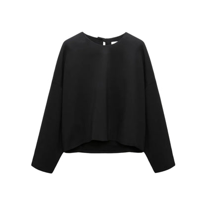 The Dorothee Schumacher Emotional Essence Blouse is an oversized black long-sleeve pullover top with a round neckline, shown on a white background.