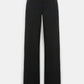 The Dorothee Schumacher Emotional Essence Pants are black, high-waisted, wide-leg trousers crafted from soft Punto Milano fabric. Shown against a plain white background, they feature side pockets, a flat front, and an elegant unfinished hemline that adds a modern touch.