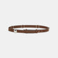 The True Cuoio Stud Belt by Dorothee Schumacher is crafted from soft brown calfskin and features silver rings, a bold silver spherical accent, and a sleek pin stud closure, presented against a white background.