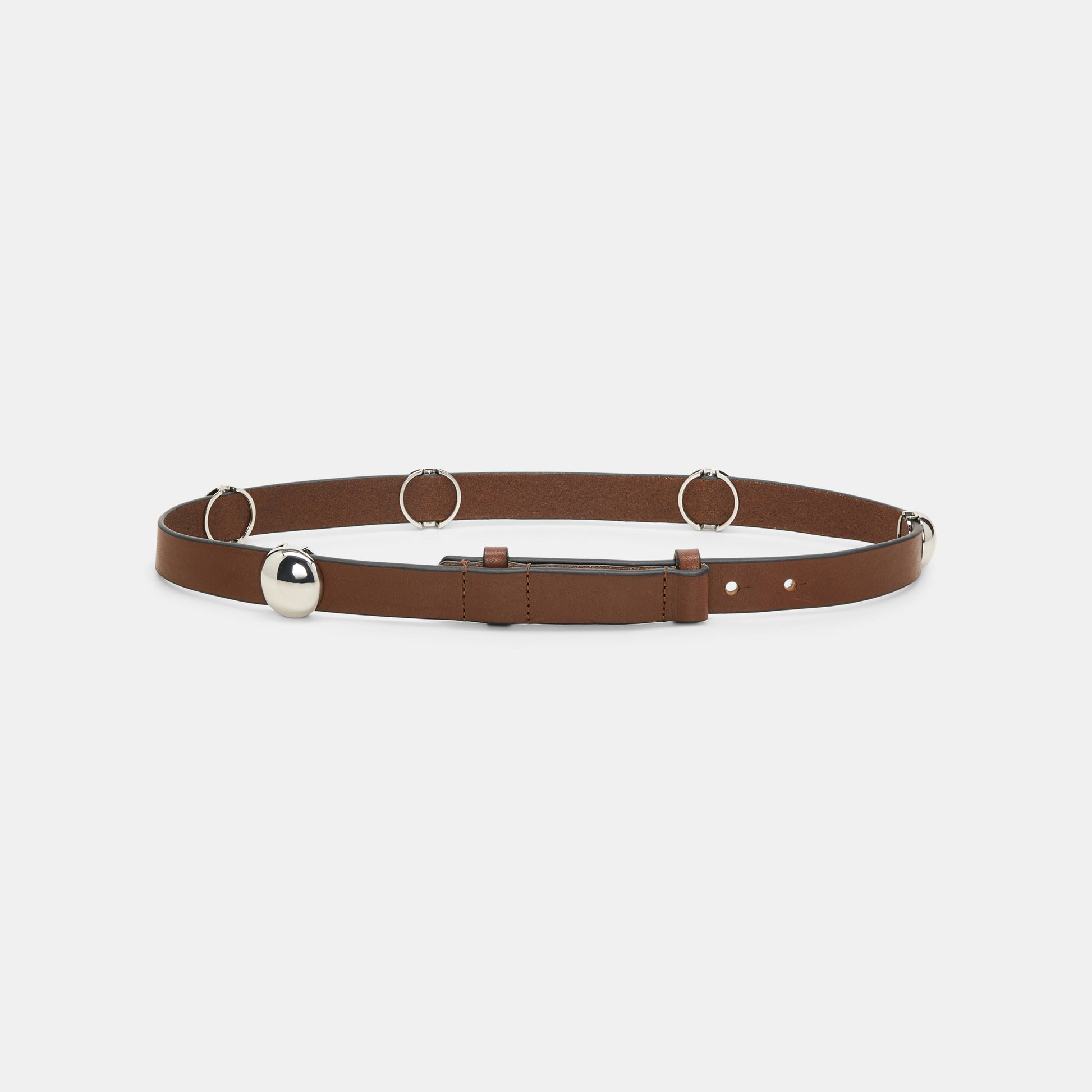 The True Cuoio Stud Belt by Dorothee Schumacher is crafted from soft brown calfskin and features silver rings, a bold silver spherical accent, and a sleek pin stud closure, presented against a white background.