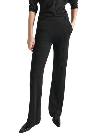 Dorothee Schumacher Shimmering Merino Trousers in dark gray with a center seam, worn with a matching shimmering knit top and pointed-toe shoes.
