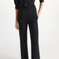 A person wearing a shimmering Merino-Lurex button-down shirt with elbow-length sleeves and matching high-waisted flared Shimmering Merino Trouser pants by Dorothee Schumacher.