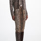 A person wearing a leopard print cardigan and the matching Dorothee Schumacher Wild at Heart Skirt with tall brown leather boots.