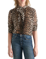 Dorothee Schumacher Wild at Heart leopard print viscose georgette blouse with a pussy-bow neckline, worn with blue denim jeans.