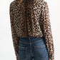 A person seen from behind, wearing a Dorothee Schumacher Wild at Heart Blouse with a high collar tucked into blue jeans.