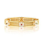 The Villandry Fleur Vine Hinged Bangle by Juliska Capucine De Wulf features golden leaf motifs and white enamel daisy flowers with gemstone centers, evoking an elegant mother of pearl look against a white background.