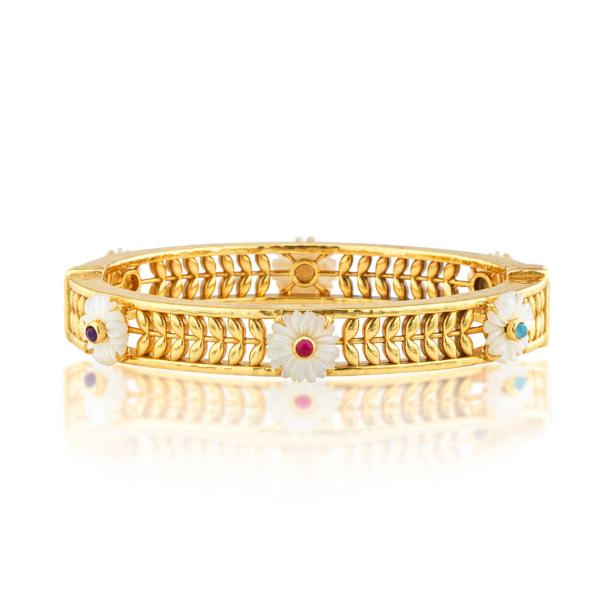 The Villandry Fleur Vine Hinged Bangle by Juliska Capucine De Wulf features golden leaf motifs and white enamel daisy flowers with gemstone centers, evoking an elegant mother of pearl look against a white background.