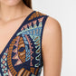 A woman wears the Emporio Sirenuse Vivienne Brise Dress, a sleeveless design featuring multicolored geometric patterns, a deep V-neckline, and delicate Brisé Cutwork.
