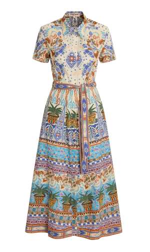 The Emporio Sirenuse Giselle Chimera Dress is a short-sleeve, button-up style with a belted waist, featuring a vibrant print inspired by Indonesian textiles in blue, orange, and green with florals, palms, and geometric motifs.