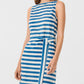 A woman wears the Emporio Sirenuse Kimi Ikat Stripes Dress, a sleeveless handwoven piece with horizontal blue and white stripes and a matching waist belt, photographed from the knees up against a plain background.