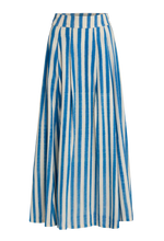 The Flaminia Ikat Stripes Skirt by Emporio Sirenuse is a long, high-waisted design with handwoven blue and white Ikat stripes, a wide waistband, and a flared, flowing silhouette.