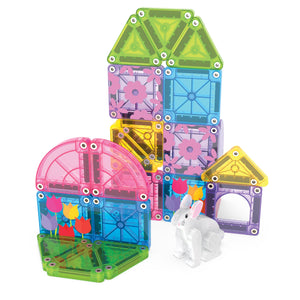 Vibrant MicroMags Spring Garden 24-Piece Travel Set tiles by Magnatiles are arranged into house-like structures adorned with delightful flower patterns, while a small white toy rabbit sits in front of them.