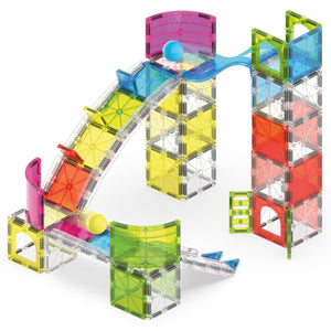 Colorful translucent magnetic tiles from the Magnatiles Rail Racers Max 80-Piece Set, an expansion pack, are assembled into a tall structure with ramps and towers, showcasing two marbles on the magnetic rail tracks.