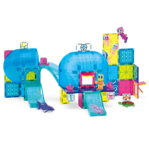 The Magnatiles Undersea Adventure 58-Piece Set features colorful plastic pieces, transparent blue dome structures, slides, block figures, marine animals, and a variety of modular building components arranged to evoke an exciting undersea adventure. Inspired by MAGNA-TILES' signature magnetic building set designs, this imaginative playset invites kids to construct and explore their very own underwater-themed world.