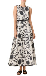 The Emporio Sirenuse Clodette Ikat Blossom dress is a sleeveless, floor-length gown in an off-white and charcoal grey floral pattern with black trim at the neckline, waist, and hem.