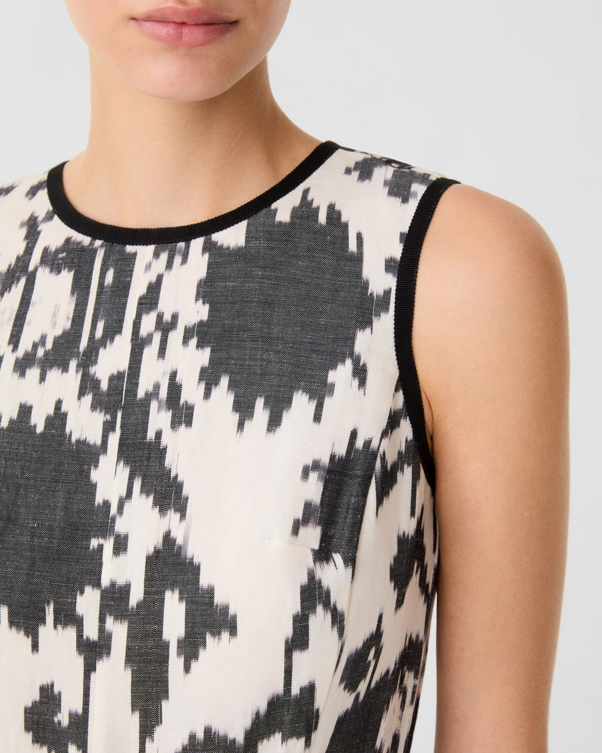Clodette Ikat Blossom Dress in a black and cream pattern with black trim at the neck and armholes.