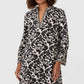 Emporio Sirenuse Giada Lotus Flower Dress, a long-sleeved tunic with a split neckline and a black and white lotus flower print.