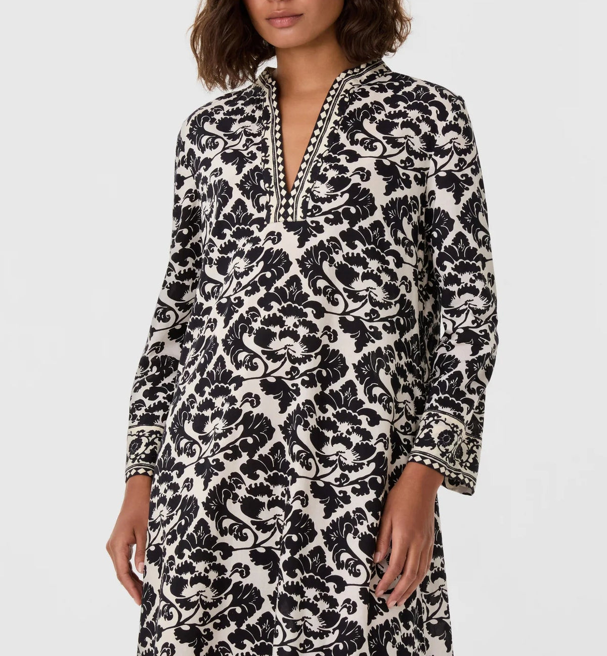 Emporio Sirenuse Giada Lotus Flower Dress, a long-sleeved tunic with a split neckline and a black and white lotus flower print.