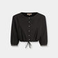 Emporio Sirenuse New Jinny Peony Embroidery Top in black cotton poplin, featuring three-quarter sleeves, an elasticized drawstring waist, and white peony embroidery on the cuffs.