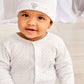 A baby in the Kissy Kissy Baby Jungle Playdate Dot Footie—a white Pima cotton outfit with grey dots and an elephant motif—sits indoors, gazing at the camera and evoking the charm of jungle animals.