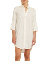 Person wearing a loose, long-sleeve, white button-down Lenny Niemeyer Chemisier Basic Dress, a timeless piece crafted from 100% viscose.