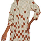 An individual is dressed in a Lenny Niemeyer Comfort Button Up Shirt Dress, showcasing a checkered geometric pattern in beige and rust tones.