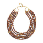 The Juliska Capucine De Wulf Earth Goddess Beads 5-Strand Necklace features hand-carved round brown teak beads, gold accents with rings at each end, and an adjustable gold clasp closure.