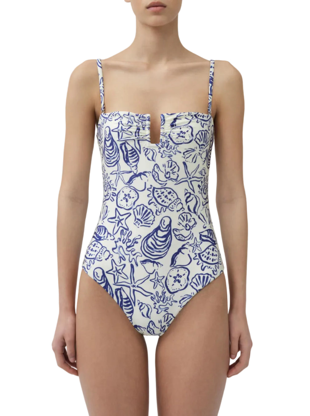 A woman wears the Simkhai Ottilie Strapless One Piece, featuring blue sea life prints, a charming seashell motif, and a notched neckline.