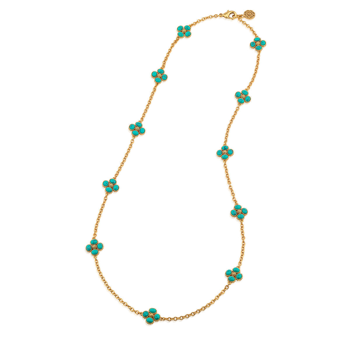 The Juliska Capucine De Wulf Berry Clover Double Sided Necklace features ten turquoise clover charms evenly spaced along a gold station chain, finished with a clasp and a small logo charm.