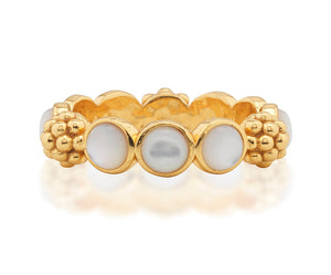 The Berry Gem Ring by Juliska Capucine De Wulf features a row of round white pearls set between clusters of textured gold beads, adding a delicate and elegant touch to any look.