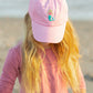 A child with long blonde hair wears a pink shirt and the Blonde Mermaid Bow Baseball Hat by Bits & Bows, standing outdoors and looking down—perfect for summer sportswear.