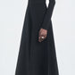 A person in the Maria McManus Button Front Dress, made from FSC-certified viscose with corozo nut buttons, and white heeled shoes stands against a plain light background.