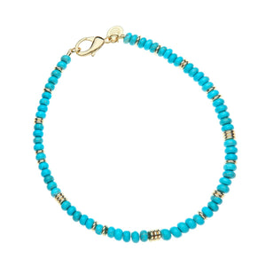 The Gumdrop Beaded Necklace Collection by Jane Win features turquoise blue beads with gold spacers and a gold lobster clasp—ideal for pairing with your favorite statement necklace.