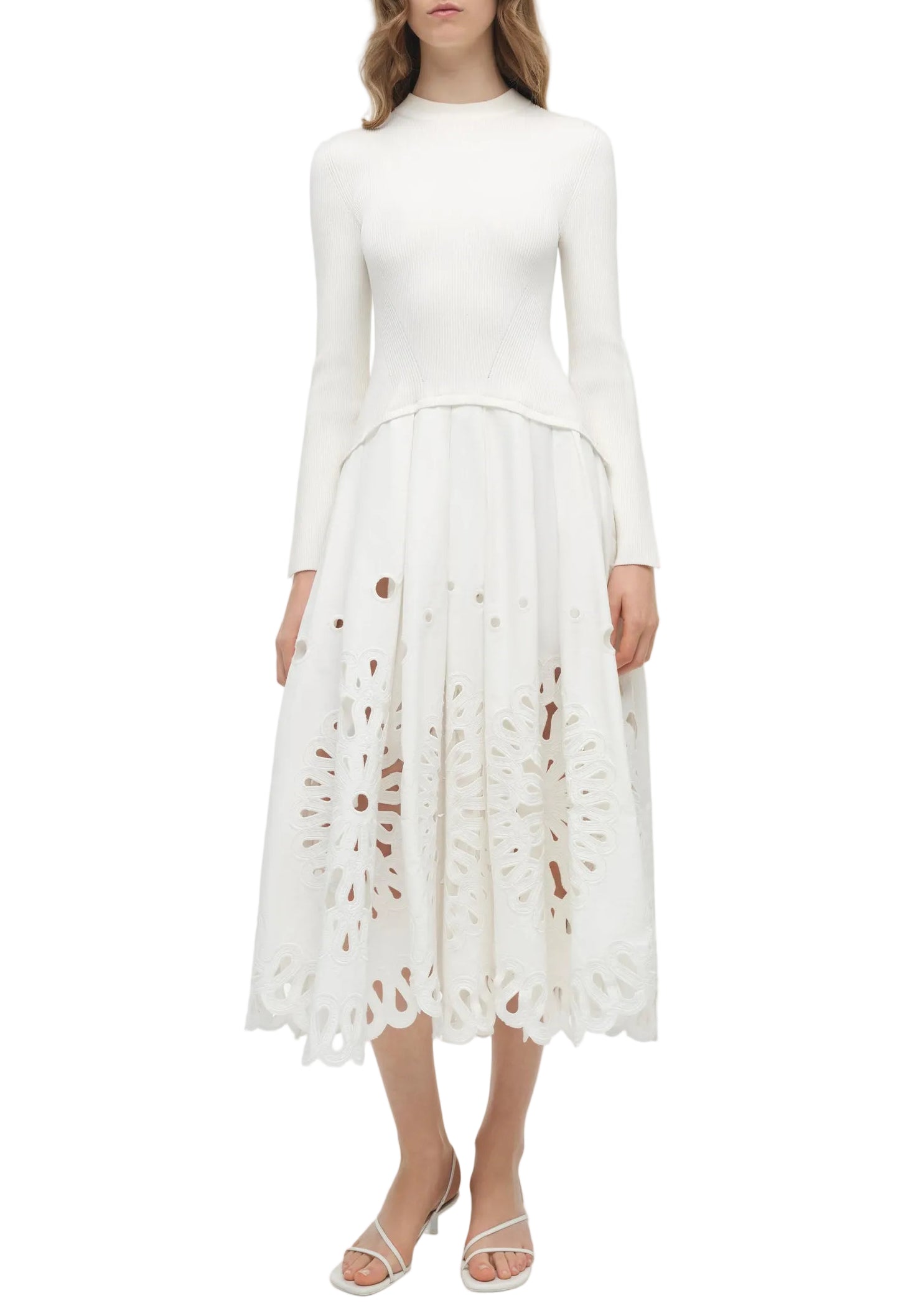 A woman wearing the Simkhai Daila Dress, featuring eyelet embroidery and a scalloped hem, paired with white sandals.