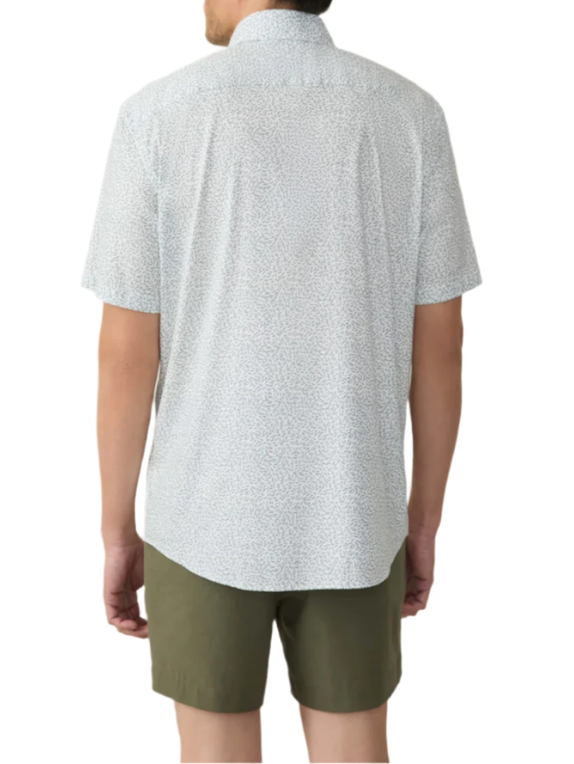 Rear view of a person in a Faherty Short-Sleeve Movement™ Monterey Shirt and olive green shorts, standing against a plain white background. The textured white Supima cotton shirt ensures all-day comfort and wrinkle resistance for any occasion.
