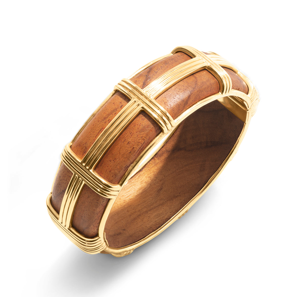The Gaia Hinged Bangle by Juliska Capucine De Wulf is a hand-carved teak wood bracelet with gold grid accents, shown on a white background.