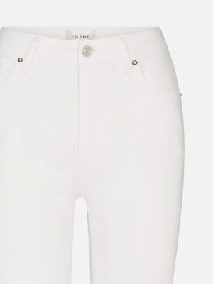 Close-up of The Reboot high-rise bootcut jeans by Frame, in white super-stretch denim with front pockets, belt loops, metallic button, zipper fly, and a visible Frame label inside the waistband.