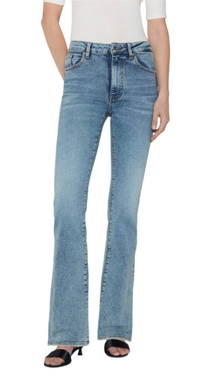 A person wearing FRAME's The Reboot light blue high-rise bootcut jeans in super stretch denim, paired with a white top and black heeled sandals, stands against a plain background.