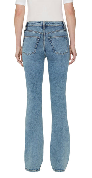 Model wears The Reboot high-rise bootcut jeans by Frame in light blue super stretch denim, shown from the back with a full-length inseam and paired with a white short-sleeve top.