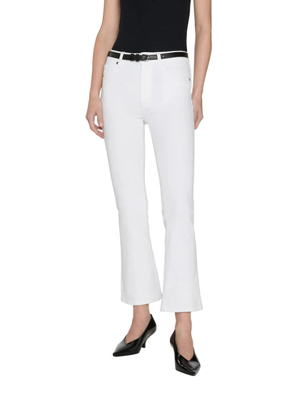 A person wearing a black sleeveless top, Frame's The Reboot Crop ultra-stretch denim bootcut jeans with a black belt, and black pointed-toe shoes, standing against a plain white background.