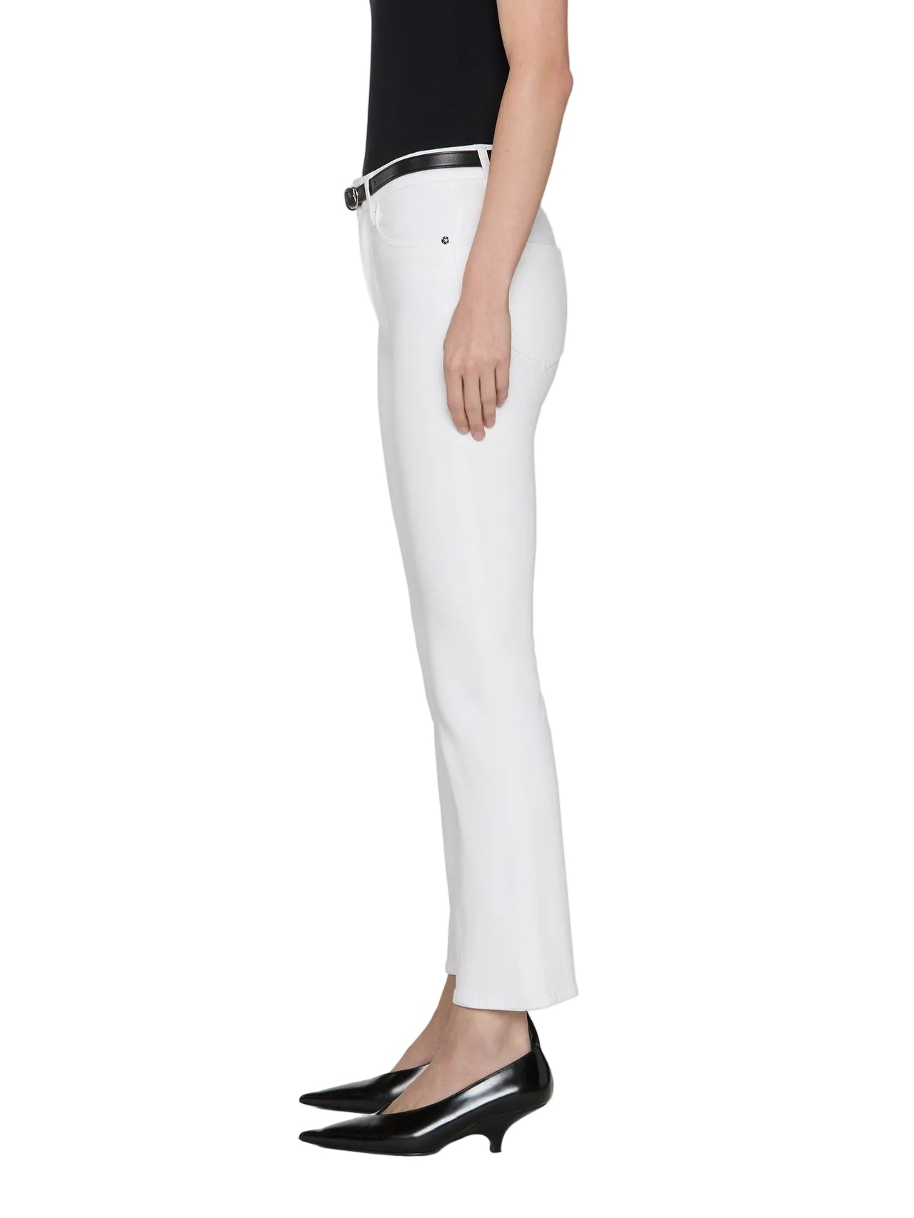 A person models Frame's The Reboot Crop ankle-length white straight-leg pants with a black sleeveless top, black belt, and black pointed-toe heels, standing in profile against a plain background.