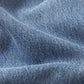 Close-up of light blue denim fabric with diagonal weave and soft folds, evoking a vintage vibe inspired by Frame's The Lax wide-leg flare jeans.