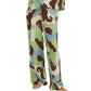 Wearing the Cara Cara Girona Pant, featuring a flowy wide-leg silhouette and an abstract swirl pattern in green, blue, brown, and cream with an adjustable tie waist, styled with sandals.