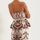 A woman is shown from the back wearing the Cara Cara Tilda Top, a strapless, fitted design with boning tape and an ornate, multicolored floral pattern, set against a plain background.