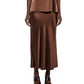 A person wearing the CO Slip Silk Skirt in brown, paired with a sleeveless top and black open-toe heeled sandals, standing against a white background.