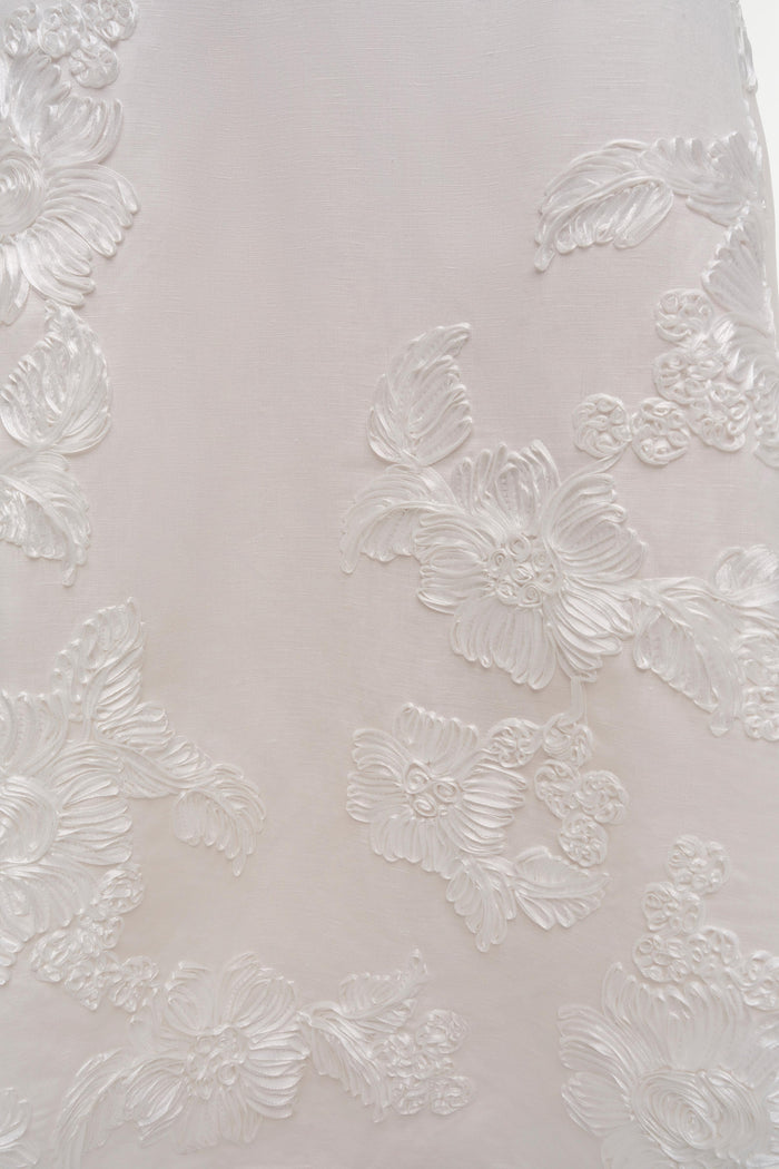 Close-up of the Annabella Soutache Dress by Simkhai, showcasing white linen-blend fabric with intricate floral soutache embroidery.